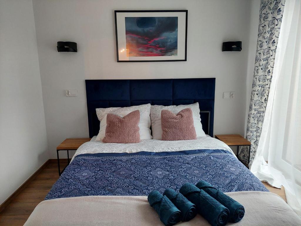 een slaapkamer met een blauw bed met 2 kussens bij Apartamenty Brenna Klimorówka in Brenna