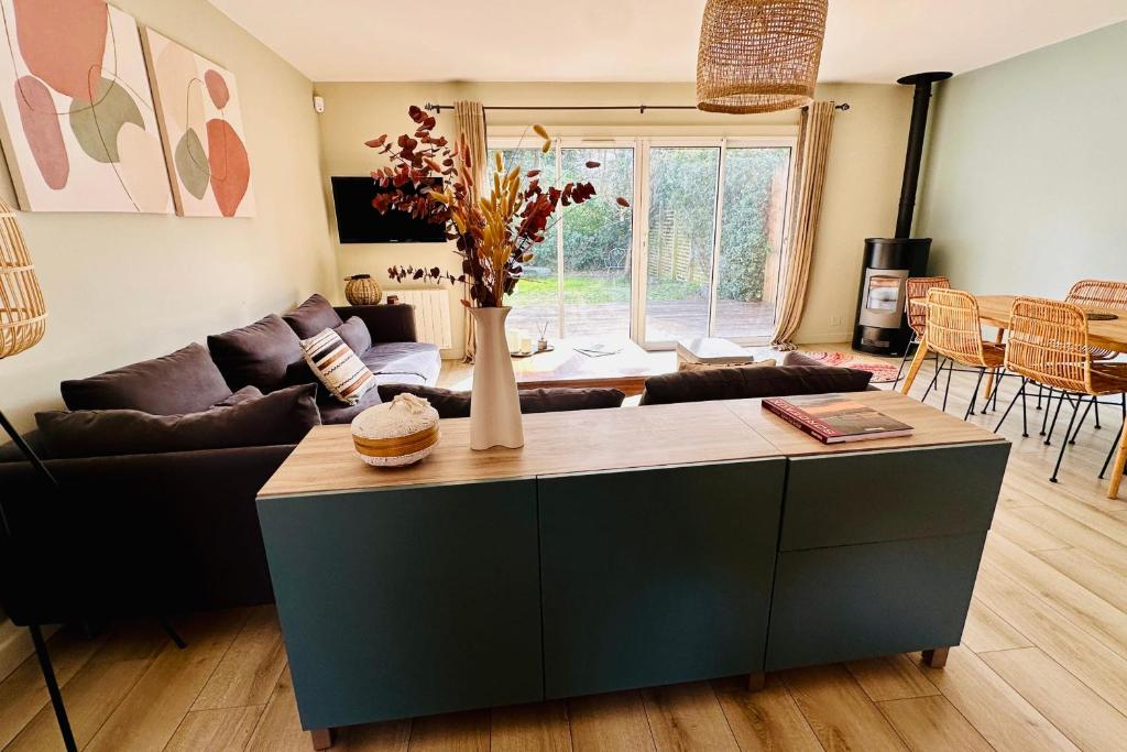 ein Wohnzimmer mit einem Sofa und einem Tisch in der Unterkunft Maison de ville avec jardin proche de Bordeaux in Le Bouscat