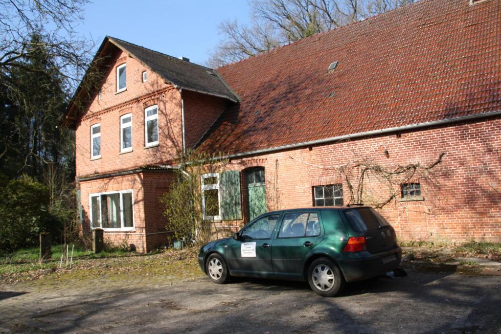 a green car parked in front of a brick building at Paschen Monteurzimmer 