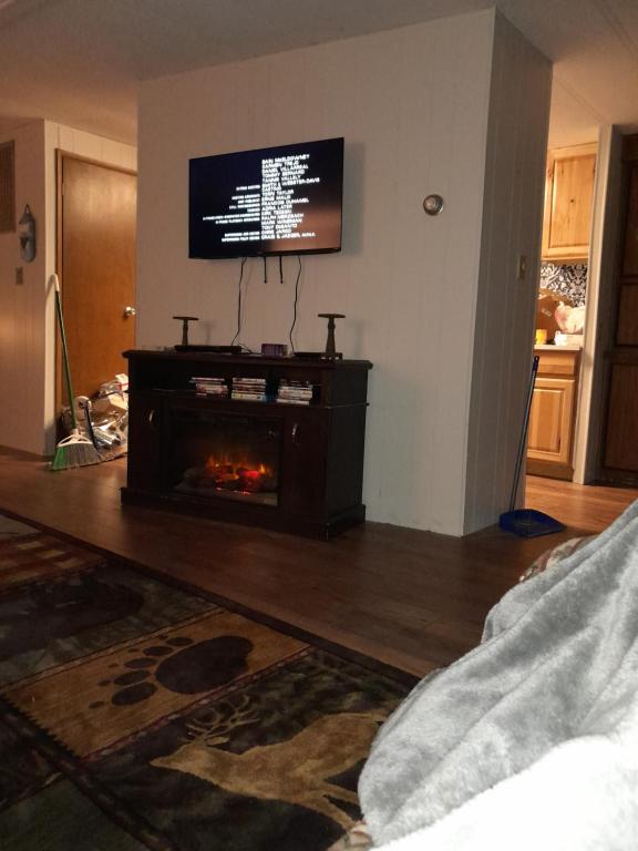 a living room with a fireplace and a flat screen tv at Mountain Hideaway in Crouch