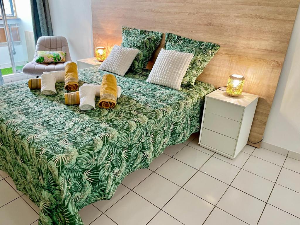 um sofá verde com almofadas num quarto em Appartement de la Mer et du Levant em Schœlcher
