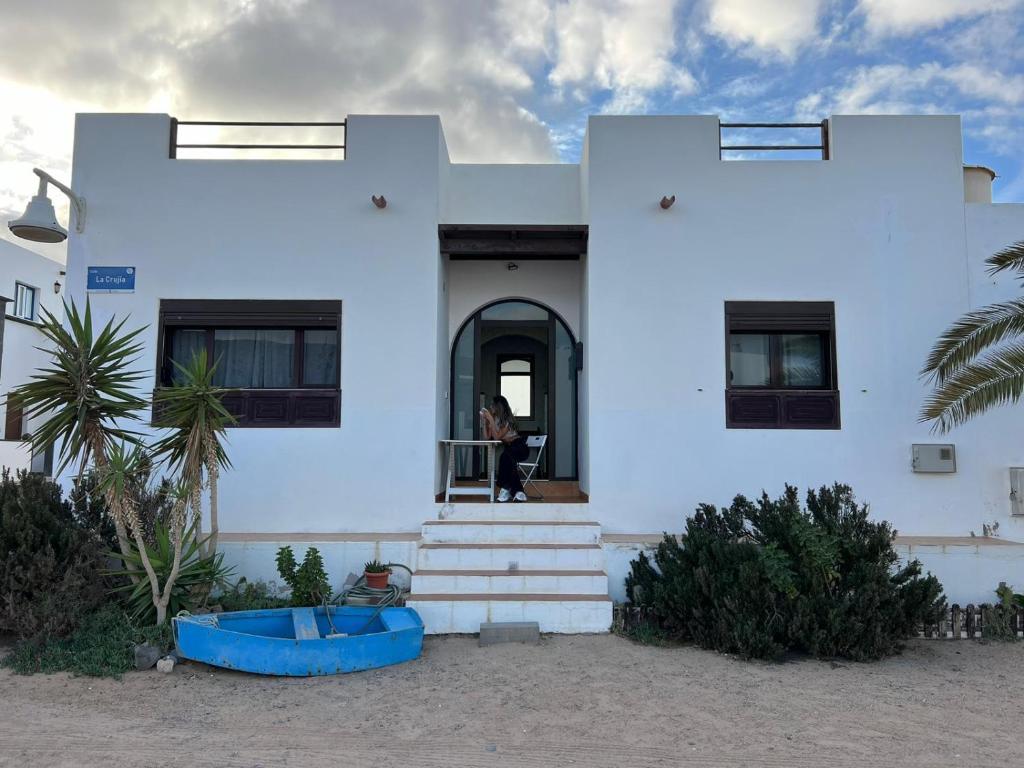 ein weißes Haus mit einer Person in der Tür in der Unterkunft Casa Olga in Caleta de Sebo