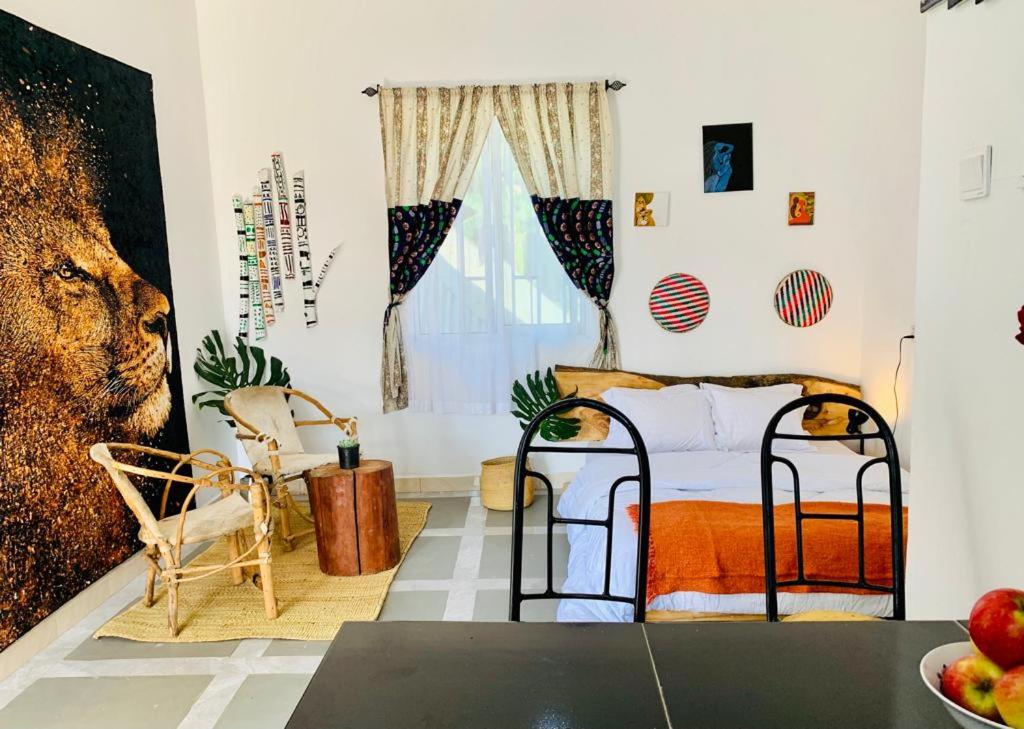 een slaapkamer met een bed en een tafel en stoelen bij Lions house arusha Airbnb in Arusha