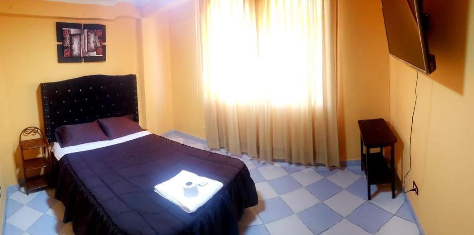 a bedroom with a bed and a large window at HOSPEDAJE RINCONCITO in Tacna