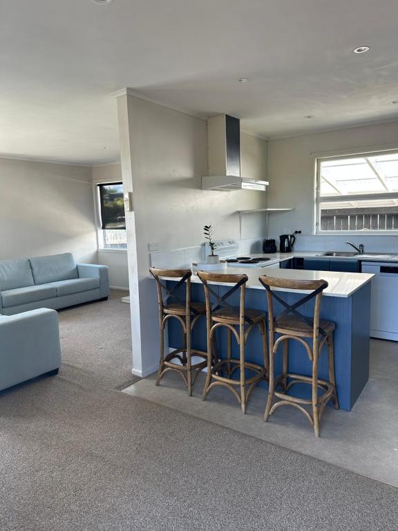 a kitchen with a blue island with bar stools at Hilltop Cottage in Taupo