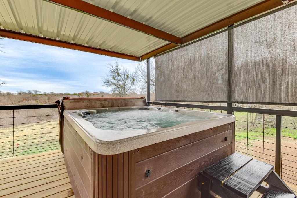 a hot tub sitting on a wooden deck with avisor at Country Creekside Haven with Private Hot Tub and Deck! in Weatherford