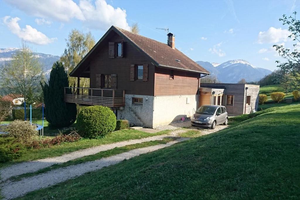 una casa con un coche aparcado delante de ella en Chalet avec grand jardin en Chartreuse Alpes, en Miribel-les-Échelles