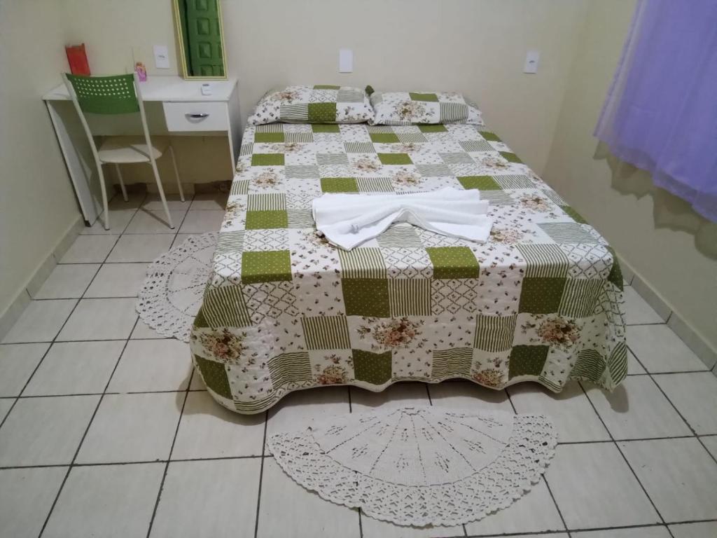 a bed with a quilt on it in a room at CASA MJ HOSPEDAGEM in Porto Velho