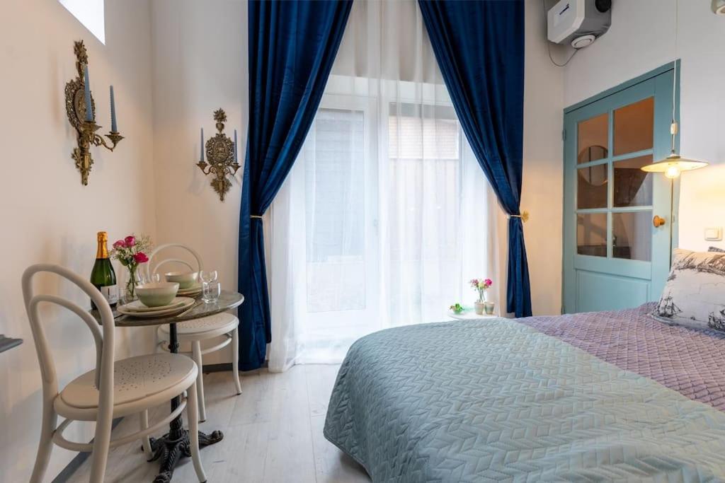 een slaapkamer met een bed, een tafel en een raam bij De Loods in Kampen