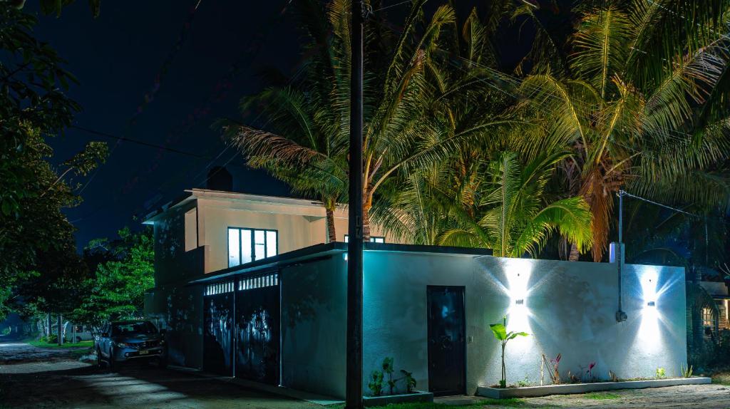 une maison avec un palmier derrière elle la nuit dans l'établissement Villa Tataya Nawi, à Monte Gordo