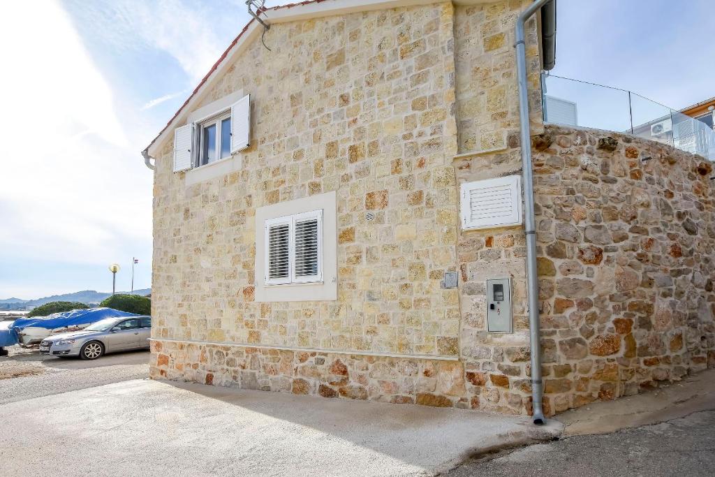 a brick building with two windows on the side of it at House Sea Stone in Dobropoljana