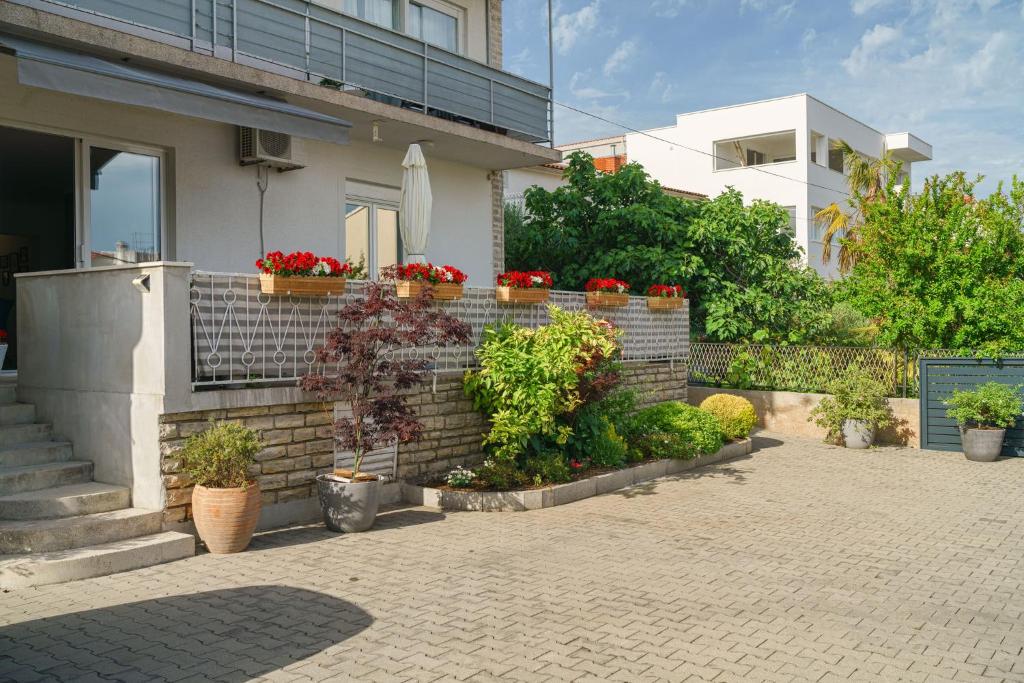 a brick wall with potted plants and flowers on it at Apartment DaNka in Vodice