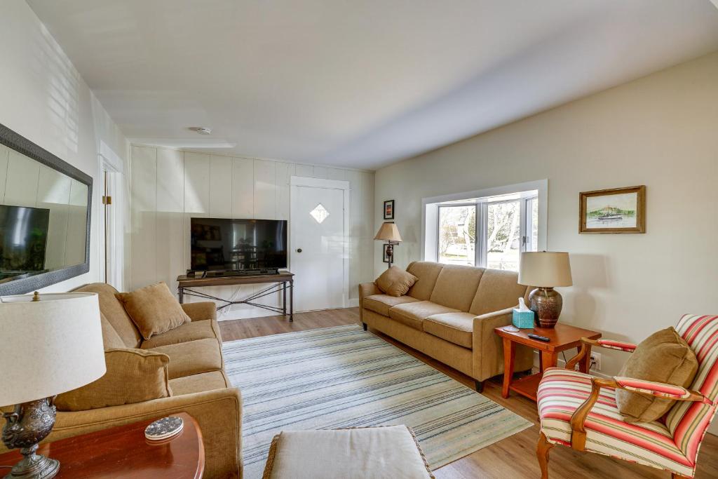 ein Wohnzimmer mit einem Sofa und einem TV in der Unterkunft Charming Muskegon Cottage - Walk to Lake Michigan! in Muskegon