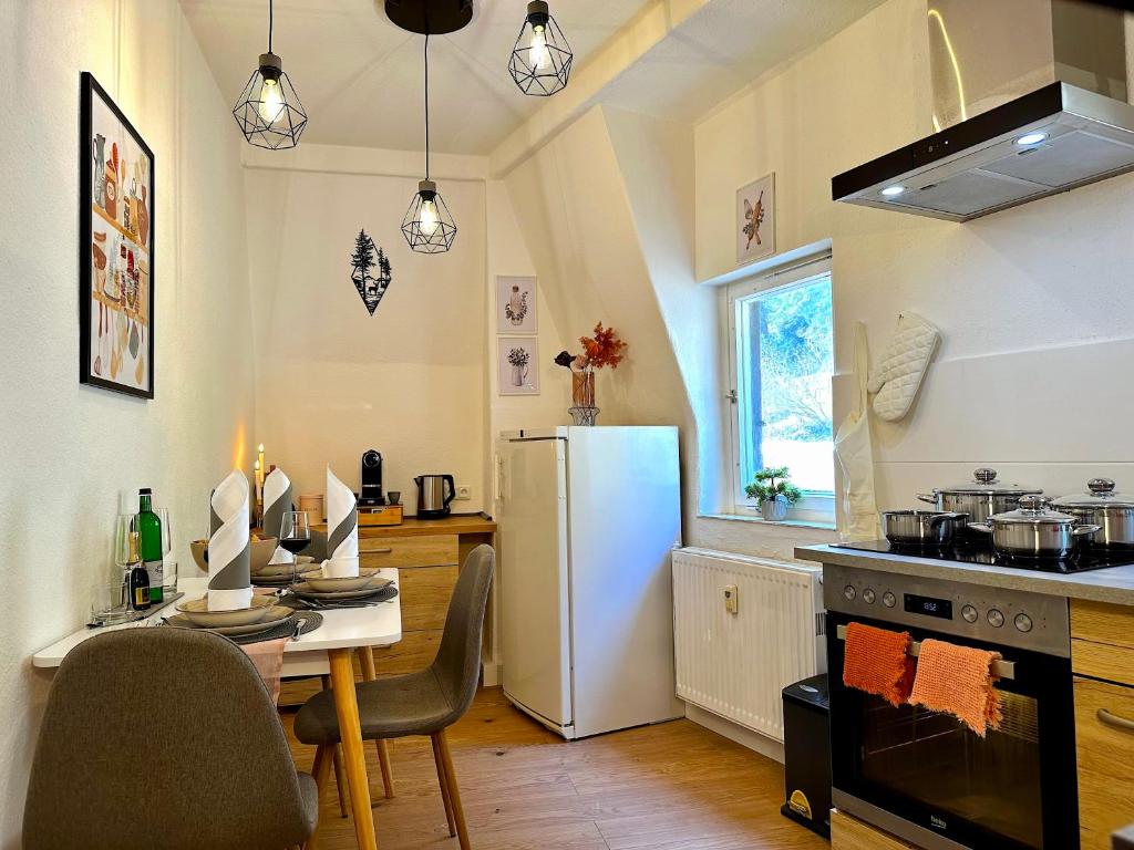 eine Küche mit einem Tisch und einem weißen Kühlschrank in der Unterkunft Boutique Apartment • Zentrum • Netflix • Parkplatz in Bad Schandau