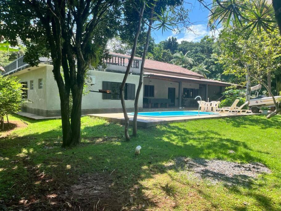 uma casa com um quintal com uma piscina em Casa grande no Guarau em Peruíbe