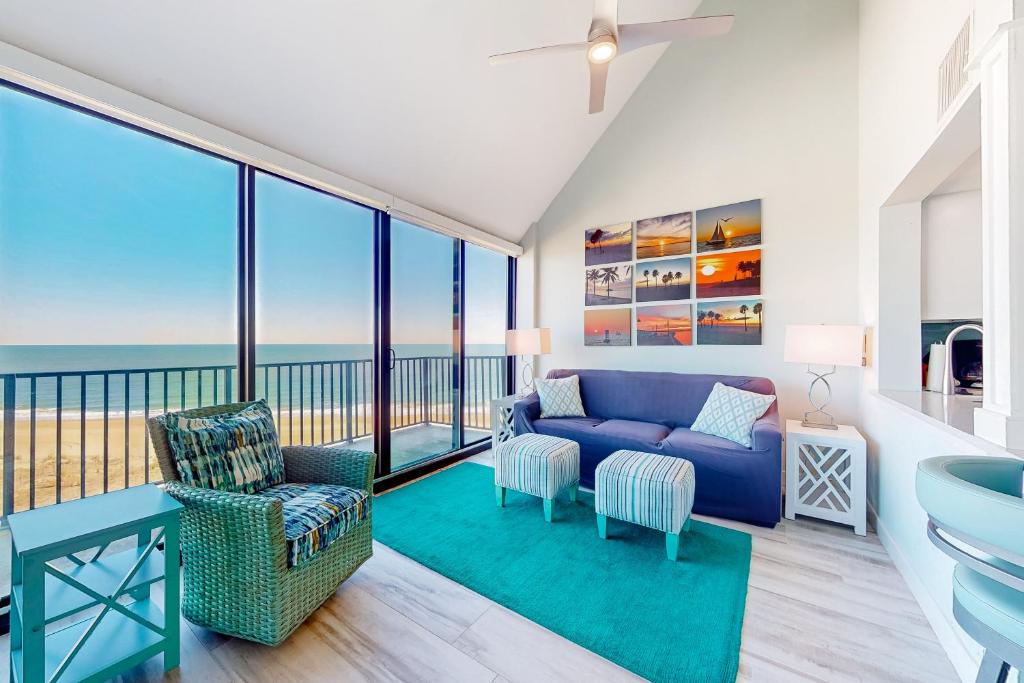 a living room with a blue couch and a balcony at Sea Colony---902 Annapolis House in Bethany Beach