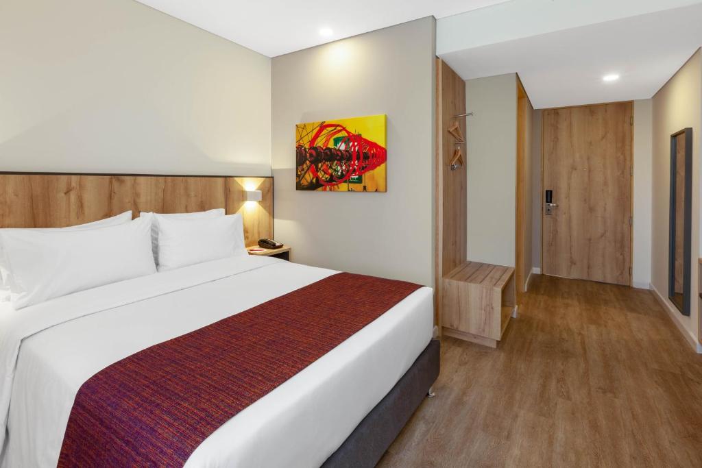 a bedroom with a large white bed in a room at Hotel Distrito ZF in Bogotá