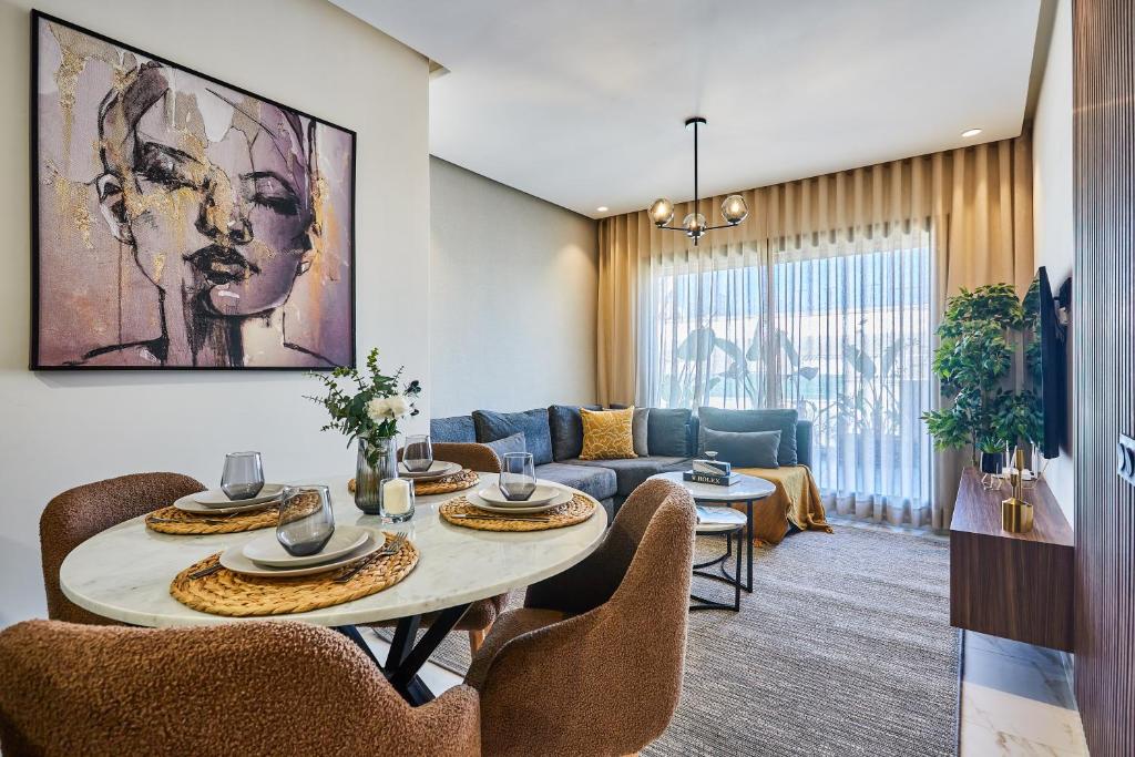 un salon avec une table, des chaises et un canapé dans l'établissement Sleek and Modern 2-Bed Unit in Downtown Casa, à Casablanca