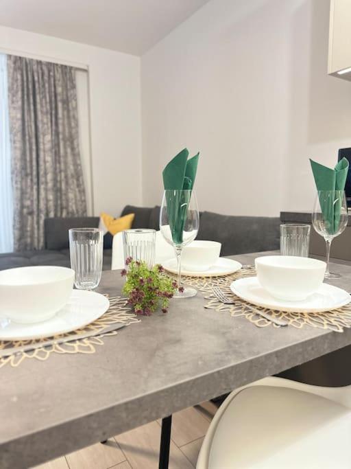 une table avec des assiettes et des verres au-dessus dans l'établissement DA apartments, à Varna