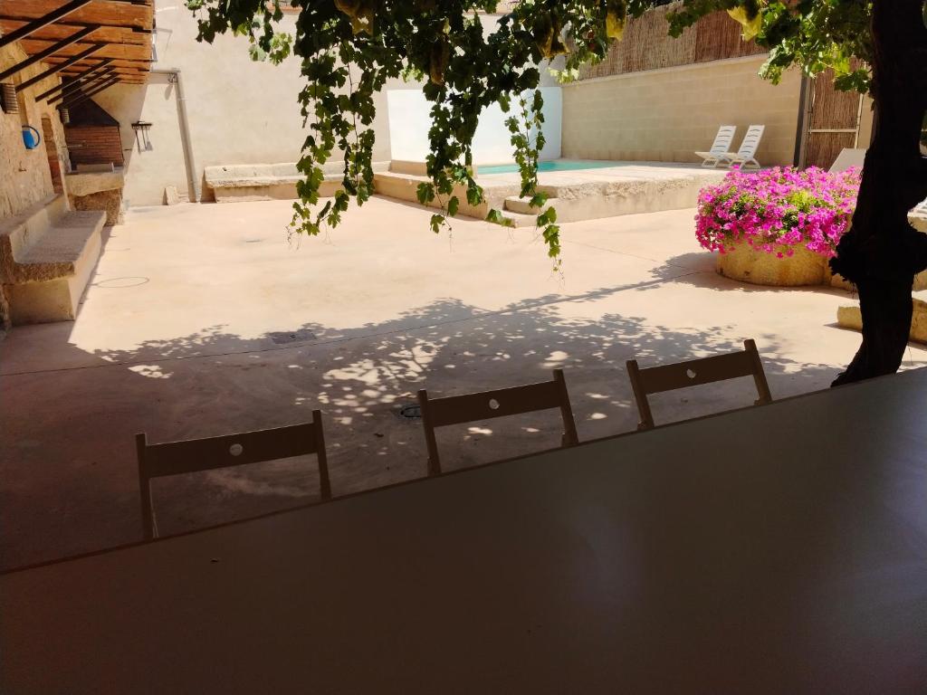 - une table et des chaises dans une terrasse fleurie dans l'établissement Casa Remunda, à Torregrosa