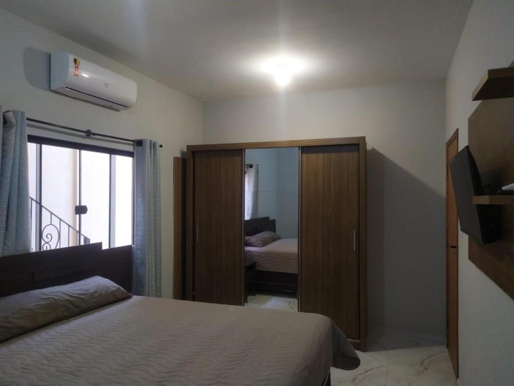 a bedroom with a bed and a closet with a mirror at Novo Horizontes in São João del Rei
