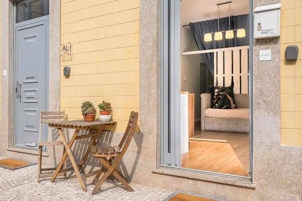 a patio with a table and chairs next to a door at Cosy House in Porto Marina in Vila Nova de Gaia