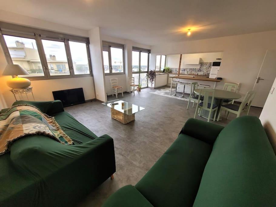 un salon avec un canapé vert et une table dans l'établissement La Case à Jeannette, à Châteauroux