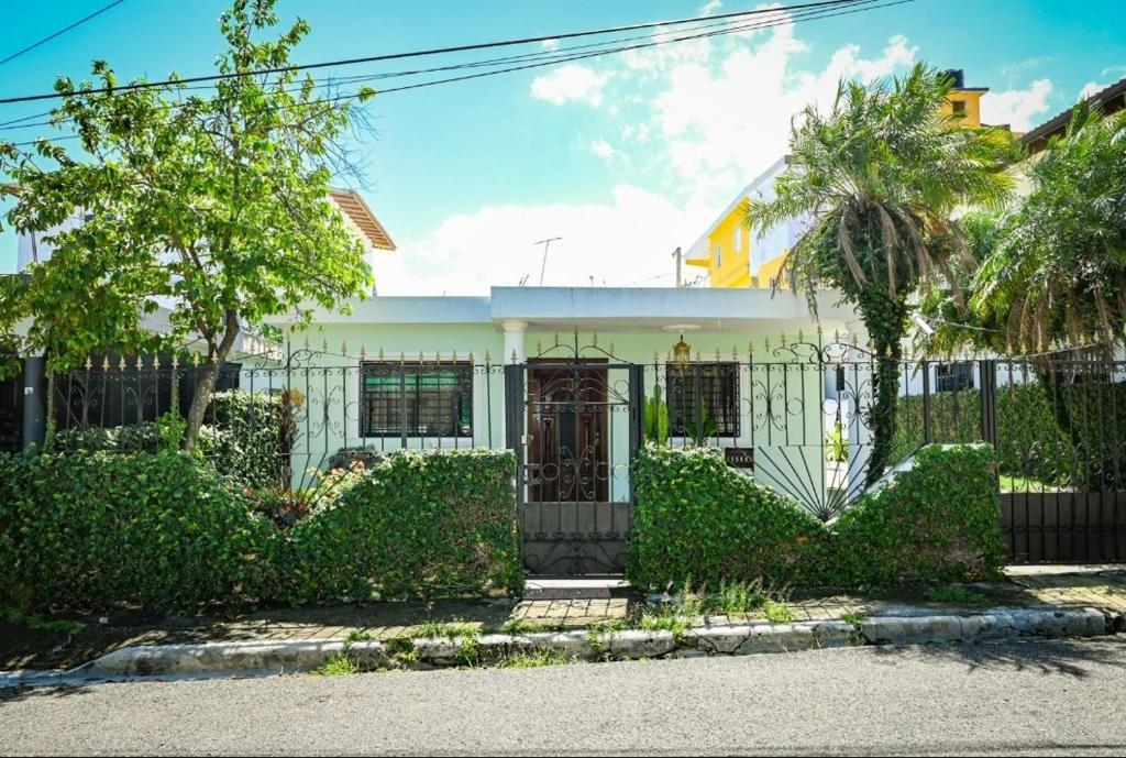 een wit huis met een hek en struiken bij Lily House 3 in San Felipe de Puerto Plata