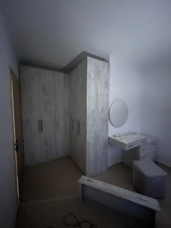 Cette petite chambre comprend un lavabo et un miroir. dans l'établissement Apartament Kristi, à Vlorë