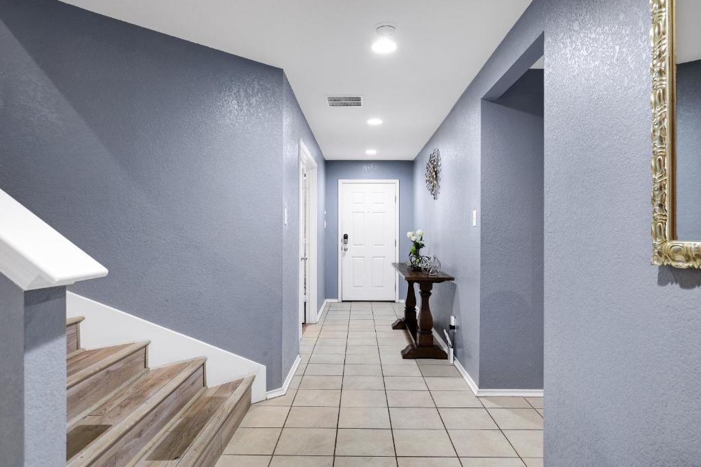 un pasillo con paredes azules y una puerta blanca en Tranquility - A Birdy Vacation Rental en San Antonio