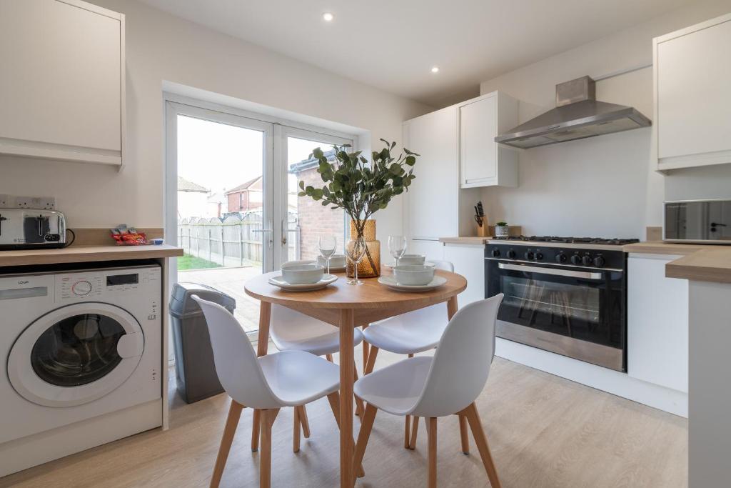 a kitchen with a table and chairs and a kitchen with a dishwasher at Elland Retreat By NordStay in Beeston Hill