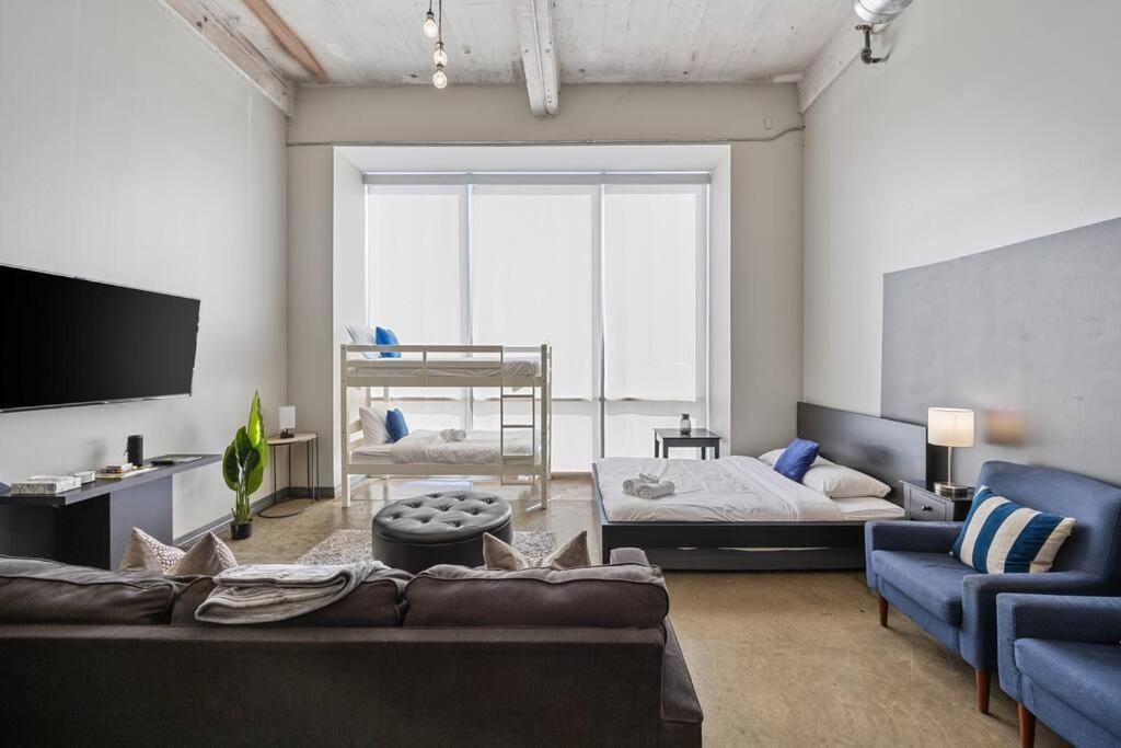 a living room with a couch and a bed at Luxurious Downtown Apt / Pool, Laundry, Parking in Dallas