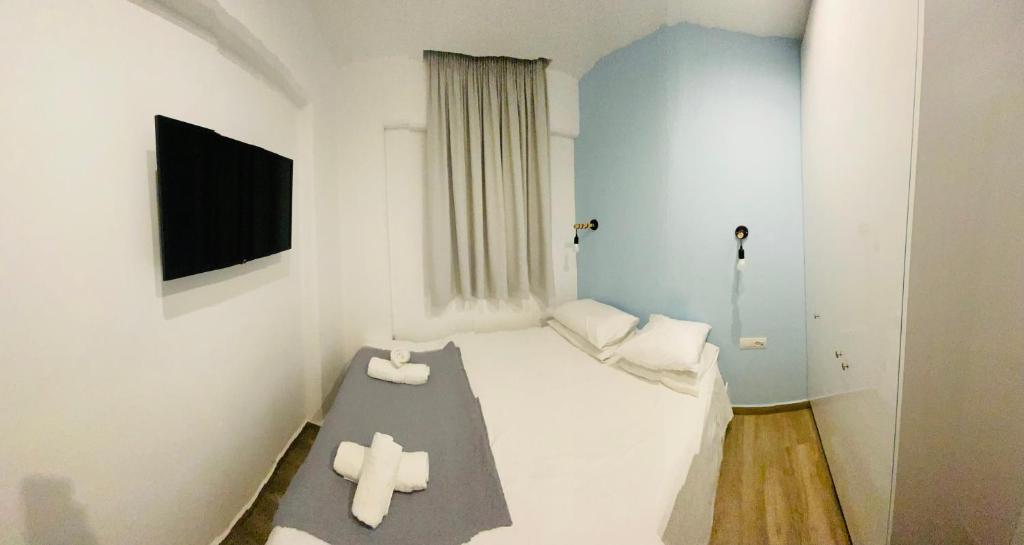 una piccola camera con un letto con due asciugamani bianchi di Block66 a Città di Rodi