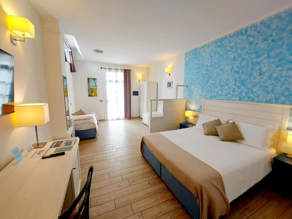 a hotel room with a large bed and a desk at Hotel La Villa Del Mare in Cagliari