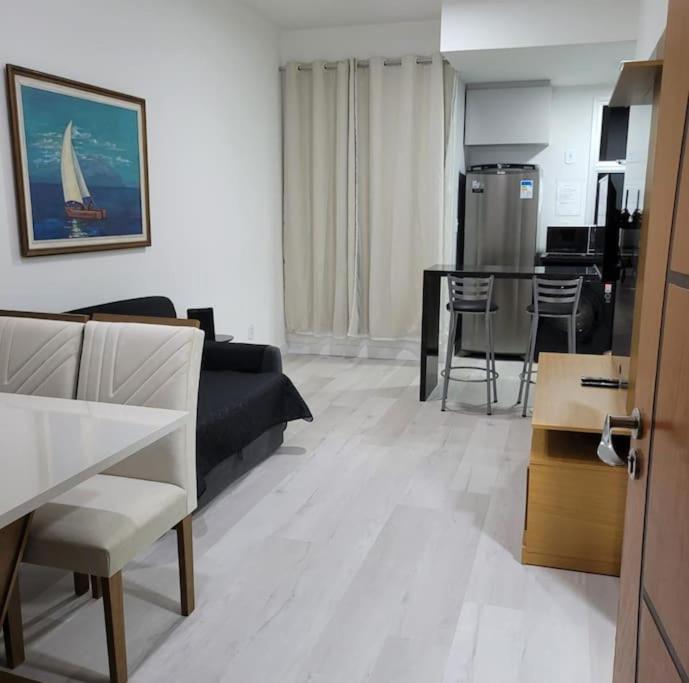 a living room with a couch and a dining room at Flat recém-reformado e bem localizado in Vitória