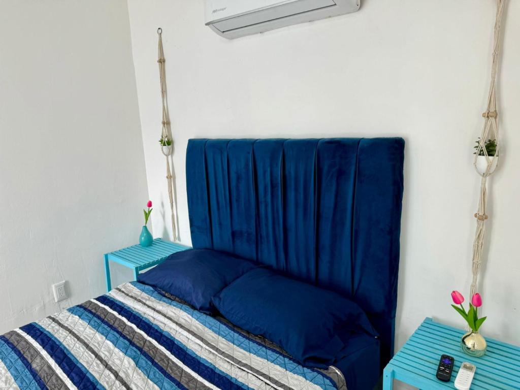 a bed with blue sheets and two blue tables at Isla Venados Habitaciones Vacacionales in Mazatlán