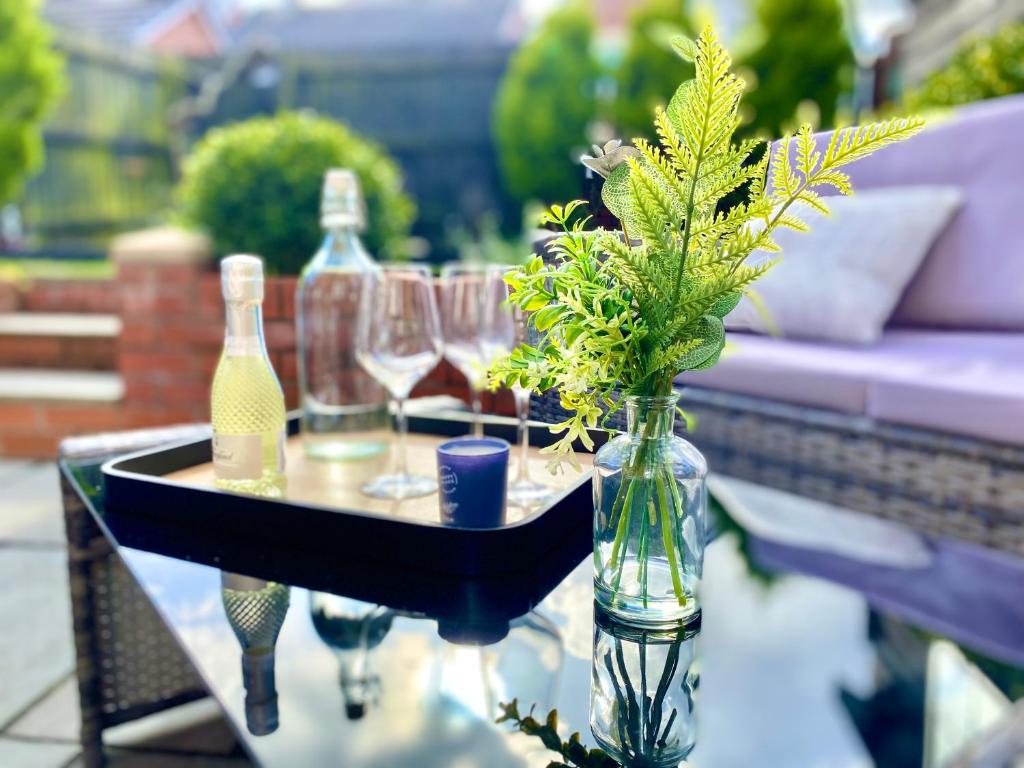 einen Tisch mit einer Vase mit Blumen und Weingläsern in der Unterkunft Entire home in Llanfoist in Abergavenny