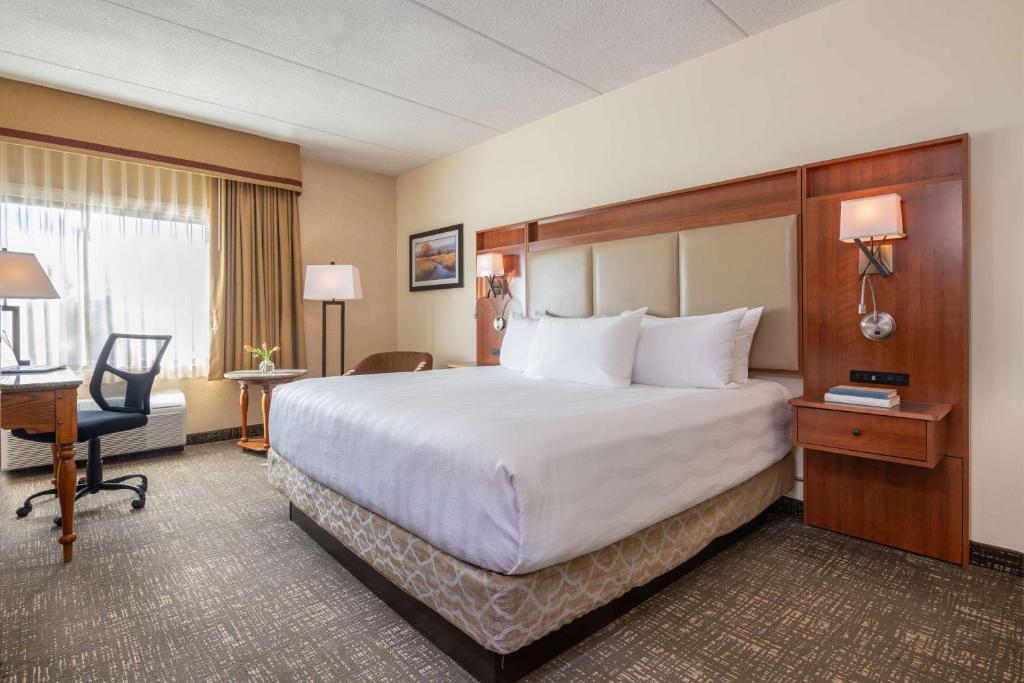 a hotel room with a large bed and a desk at Best Western Plus Waterbury - Stowe in Waterbury