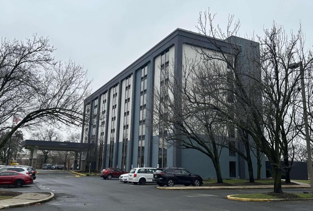 ein großes Gebäude mit Autos auf einem Parkplatz in der Unterkunft Best Western Plus Meadowlands in Secaucus