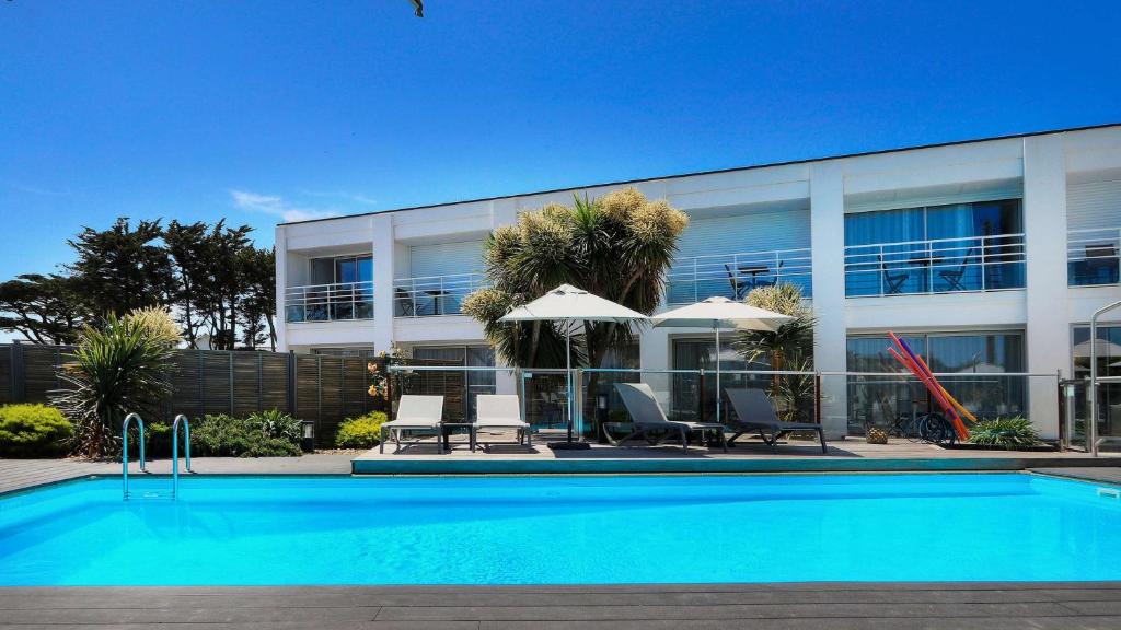 a swimming pool in front of a building at Best Western Hotel Le Bellevue in Quiberon