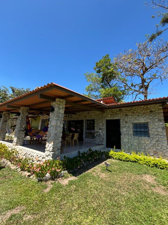 a stone house with a wooden roof and a patio at La Quinta del Valle in Llano Grande