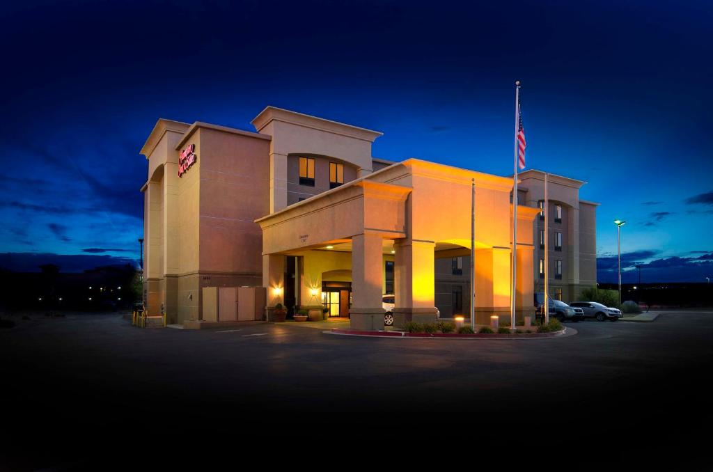 蓋洛普的住宿－Hampton Inn & Suites Gallup，停车场内悬挂美国国旗的建筑物