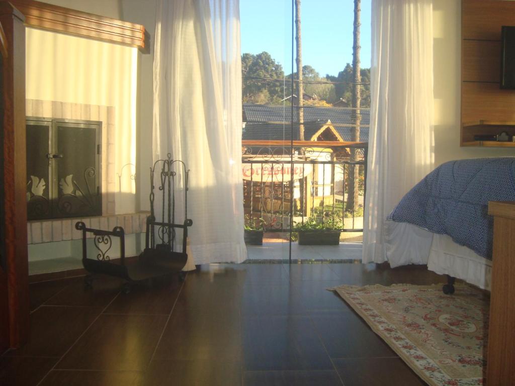 a bedroom with a bed and a large window at Caluan Apartment in Monte Verde