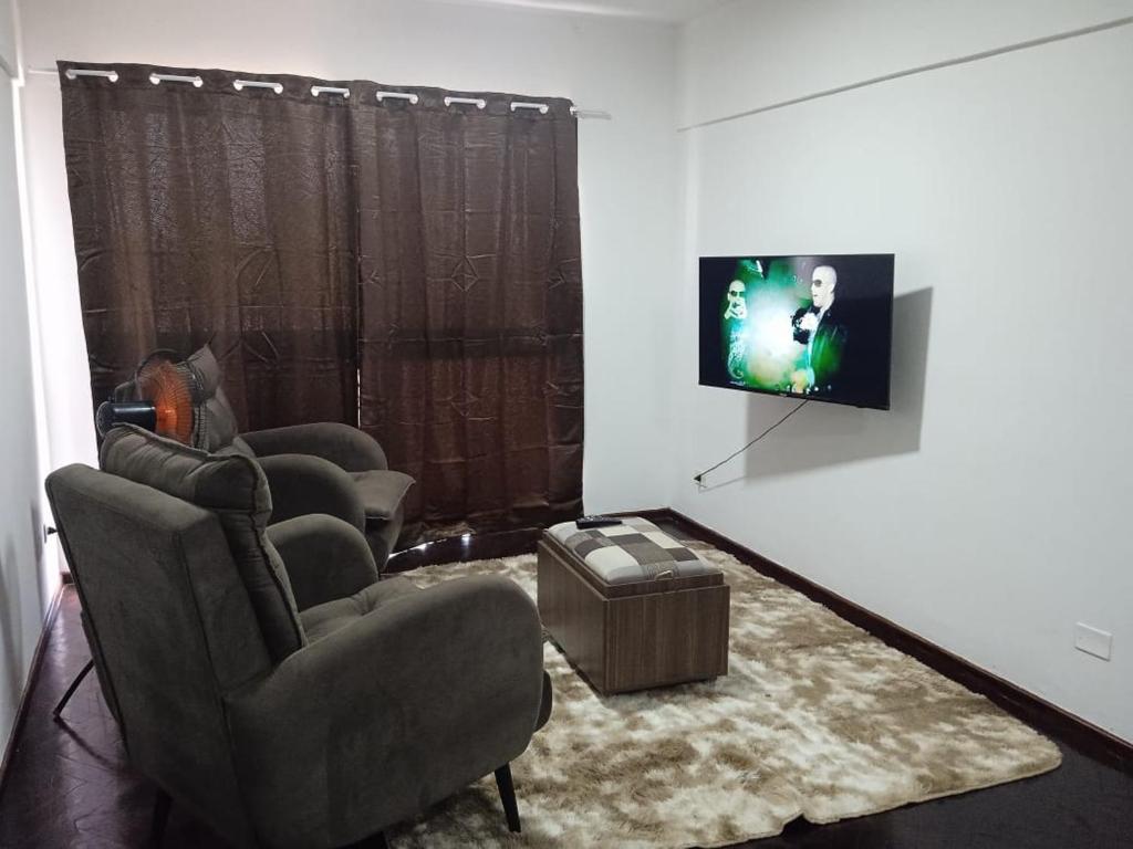a living room with three chairs and a flat screen tv at AMANDA in Ciudad del Este