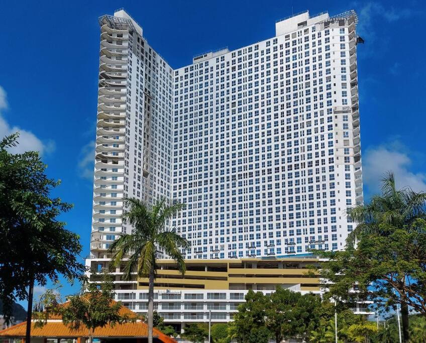 wysoki biały budynek z drzewami przed nim w obiekcie OlaMola City Apartment Panamá w Panamie