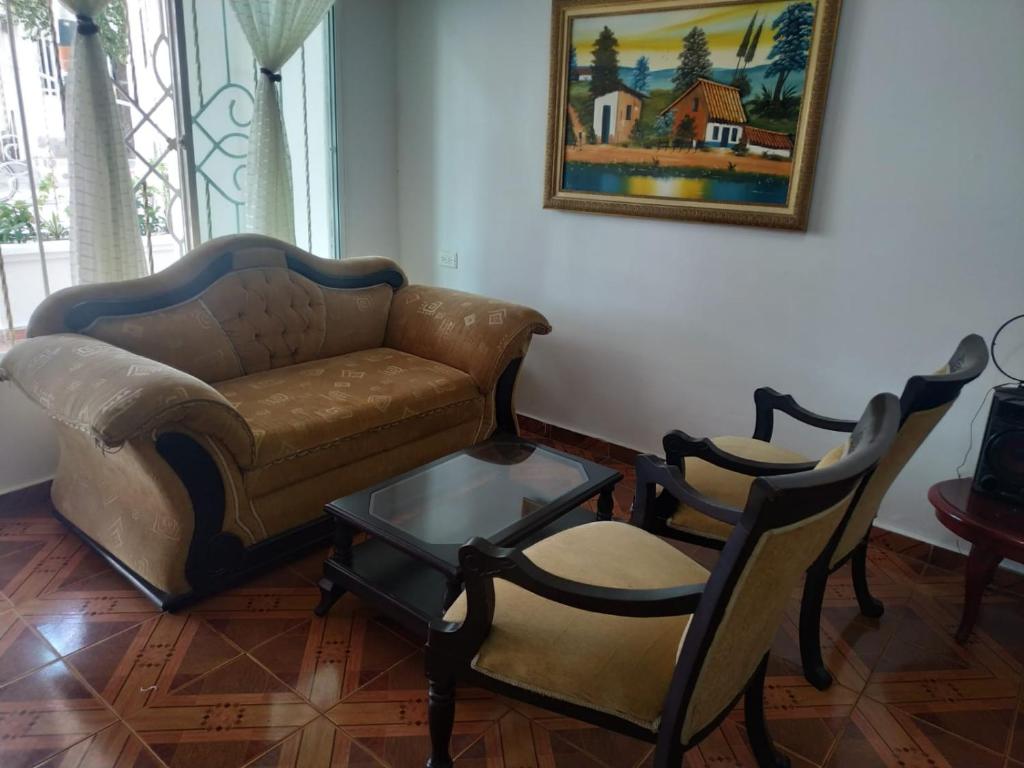 ein Wohnzimmer mit einem Sofa und 2 Stühlen in der Unterkunft Habitación Amplia cerca al Éxito de la Cra 27 in Barranquilla