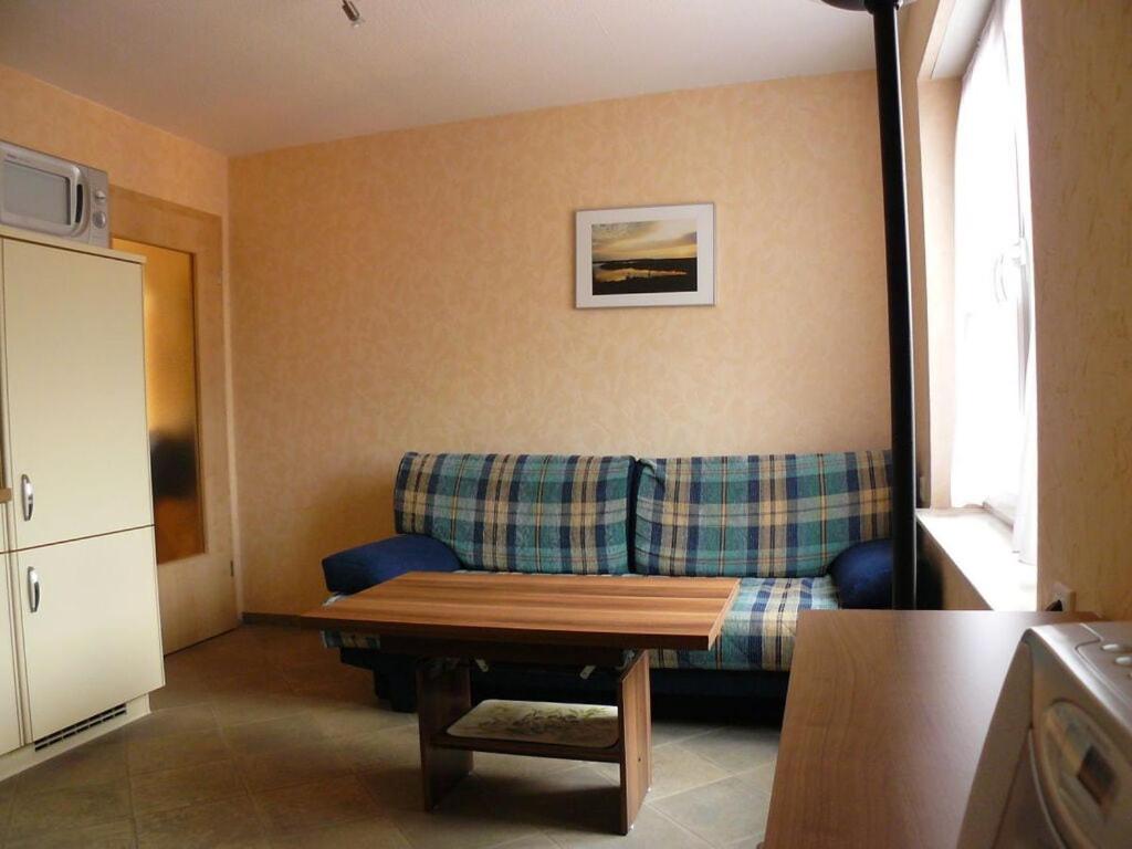 een woonkamer met een bank en een tafel bij Holiday flat in Nesso 
