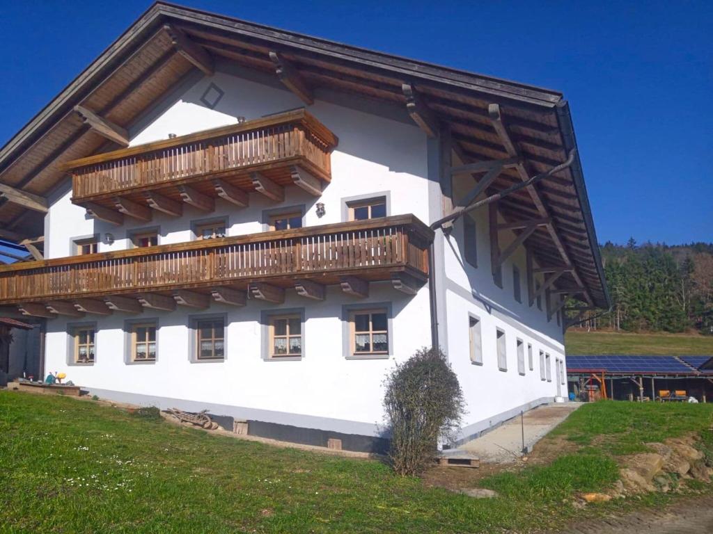 un gran edificio blanco con balcón de madera en Beautiful apartment with a fantastic terrace, en Viechtach