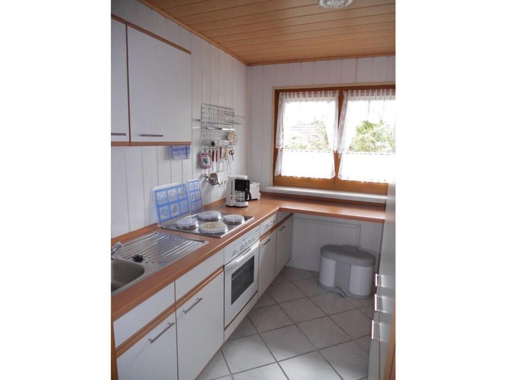 una cocina con armarios blancos y fregadero en Apartment with beautiful sea view en Pappenheim