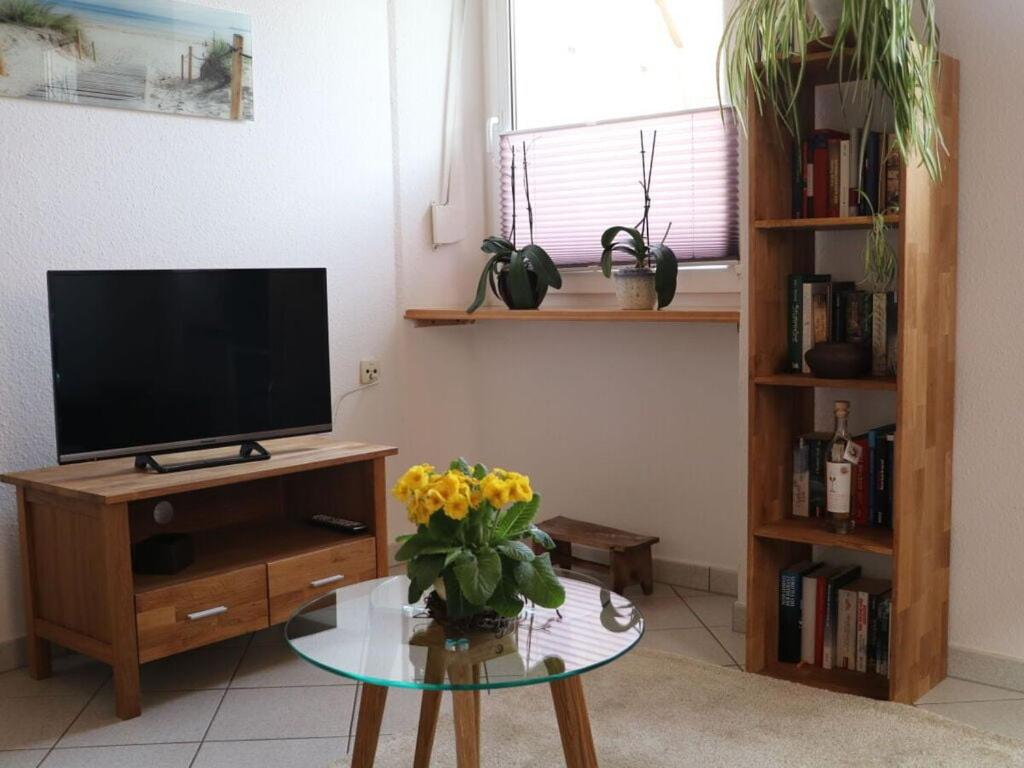 sala de estar con TV y mesa con flores amarillas en Holiday apartment Old Town Hall, en Tauberbischofsheim